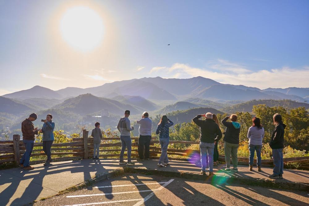A group of people stand on a hill, gazing at the valley below in Pigeon Forge.