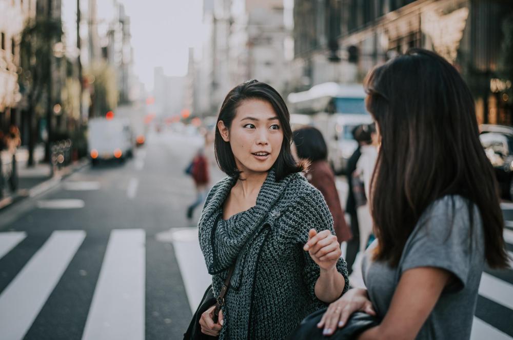 Two women talking while crossing a Kyoto street