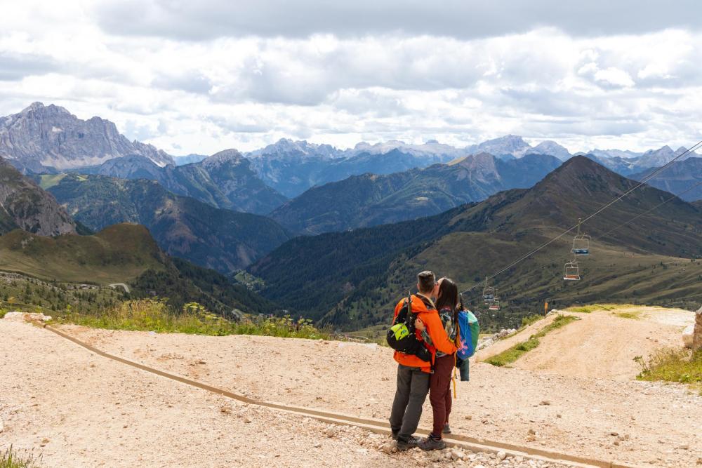 Couple standing on a mountain path overlooking the Dolomites