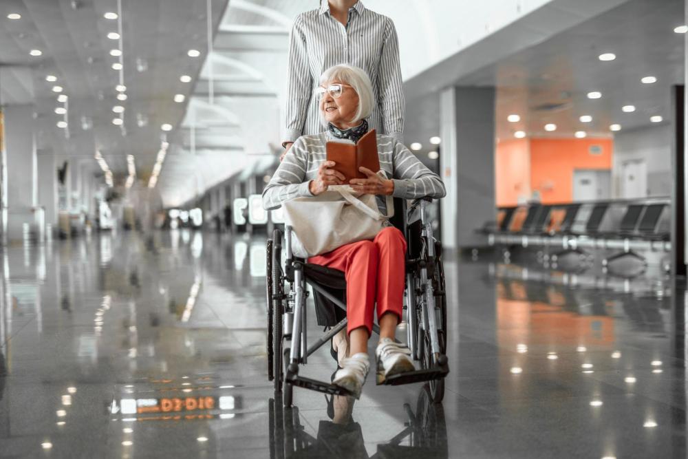空港内を移動する車椅子に乗った旅行者とスタッフ