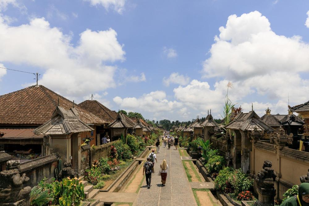 Visitors walking through a Balinese village.