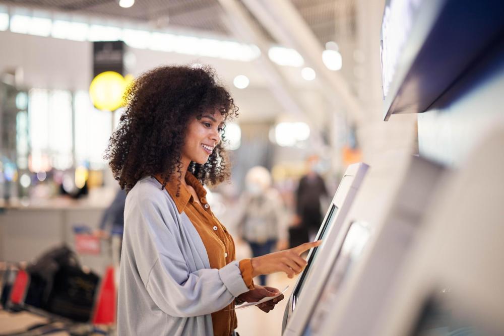 A person checking in at an airport self-service kiosk