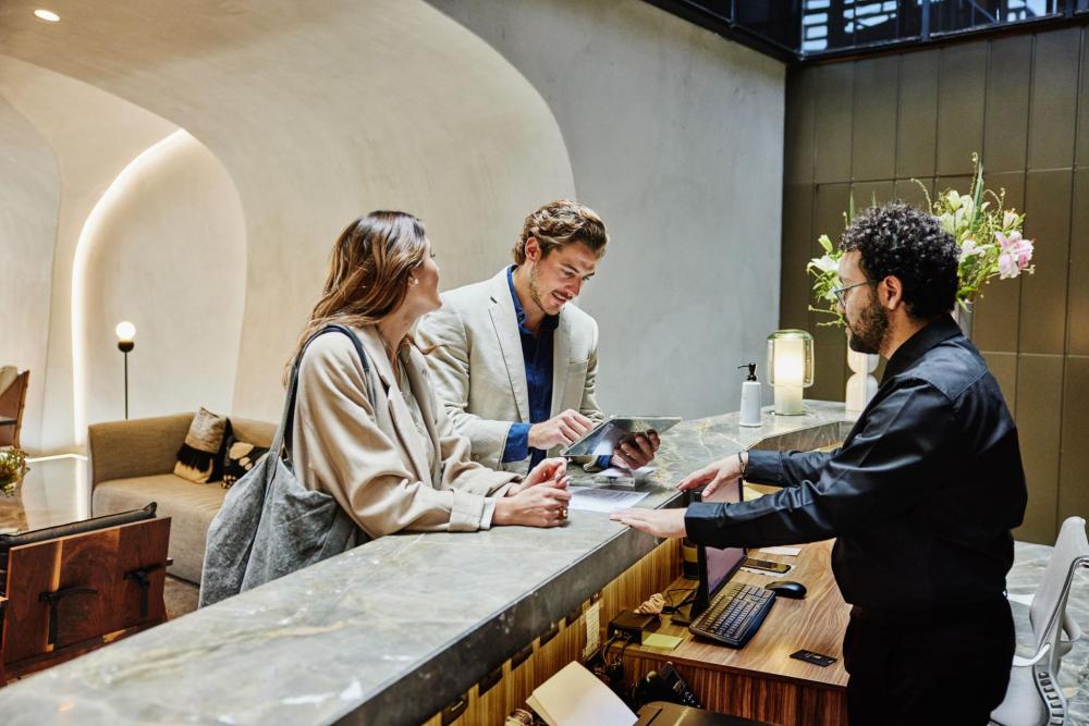A couple standing at the reception of a resort while looking over their bill