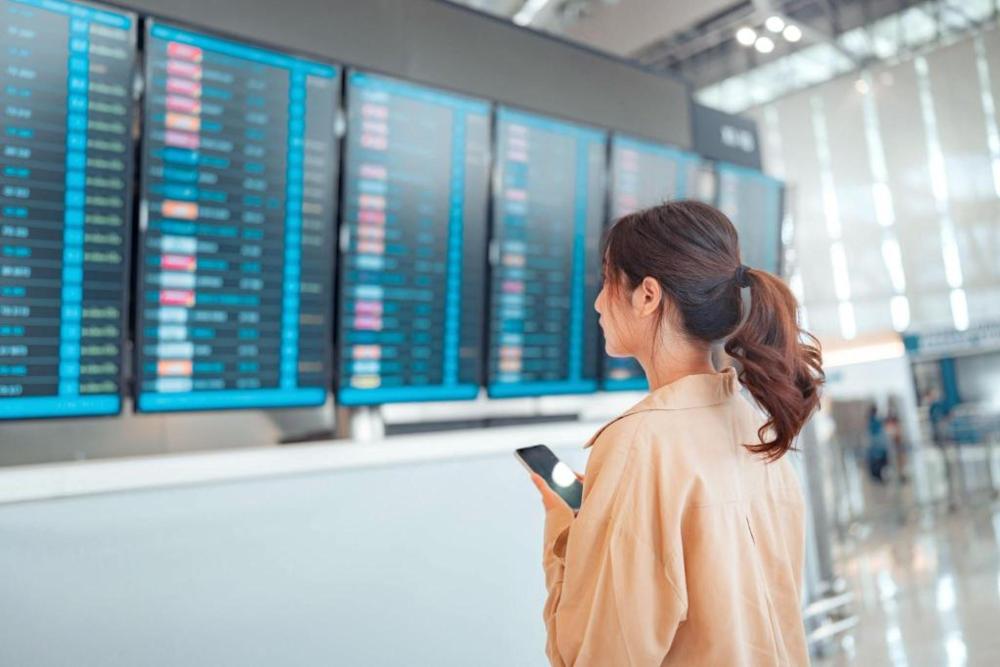 A woman looking at the airport flight board