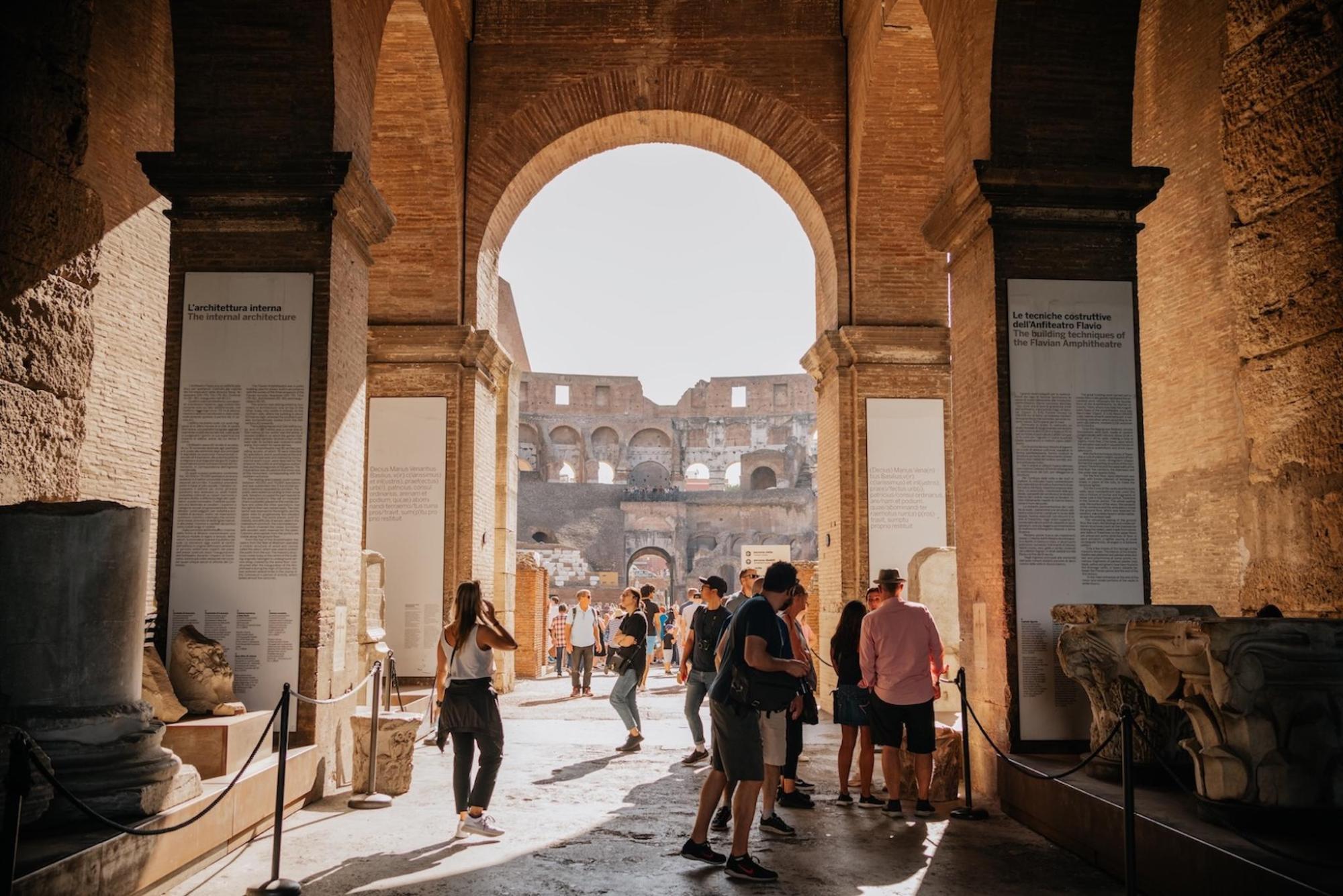  People walking through an ancient archway in the Colosseum