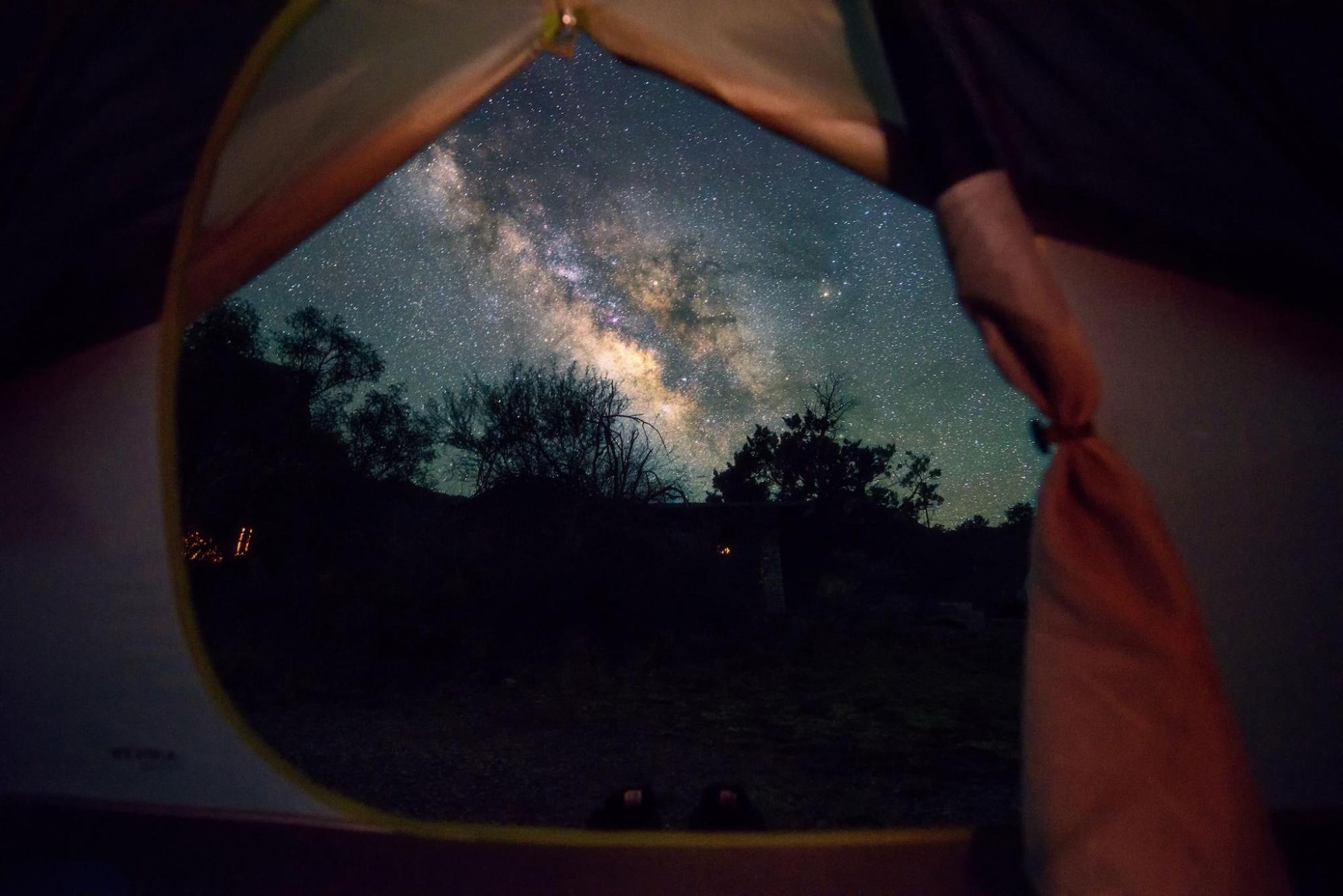 Starry night sky seen from the interior of a tent
