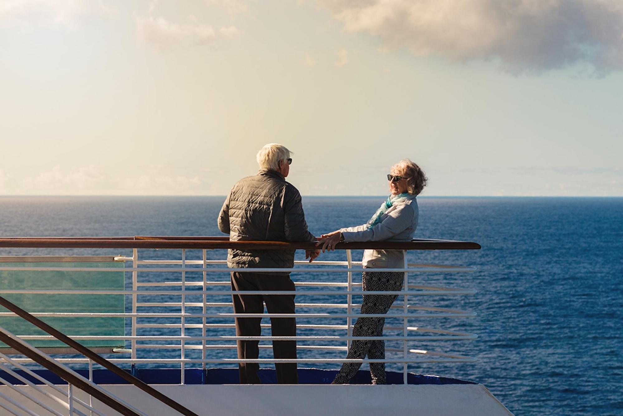 A couple enjoying the view on the deck of a cruise ship