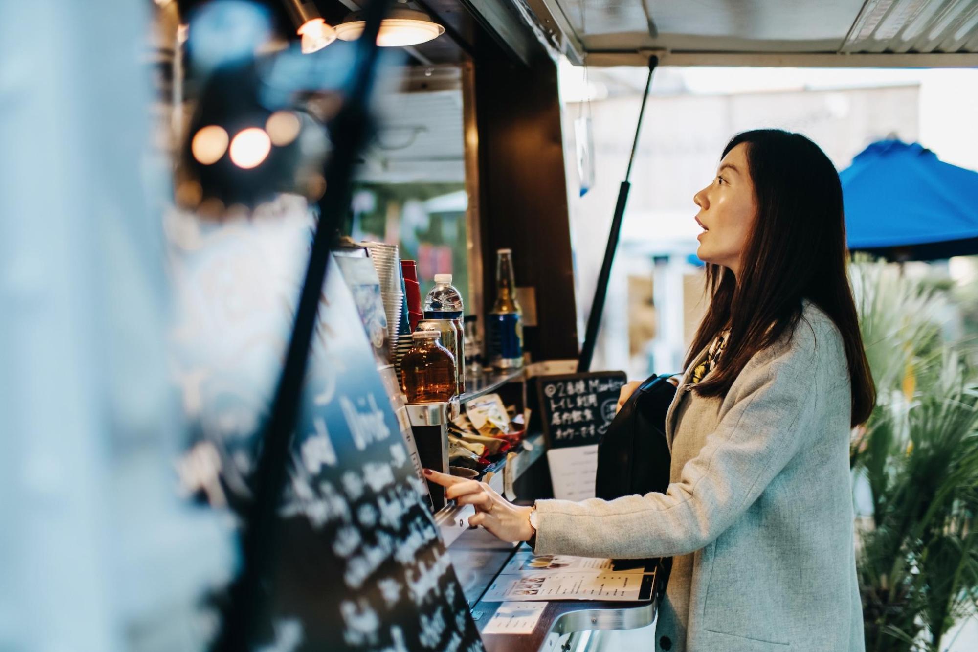 A woman orders food from a food truck