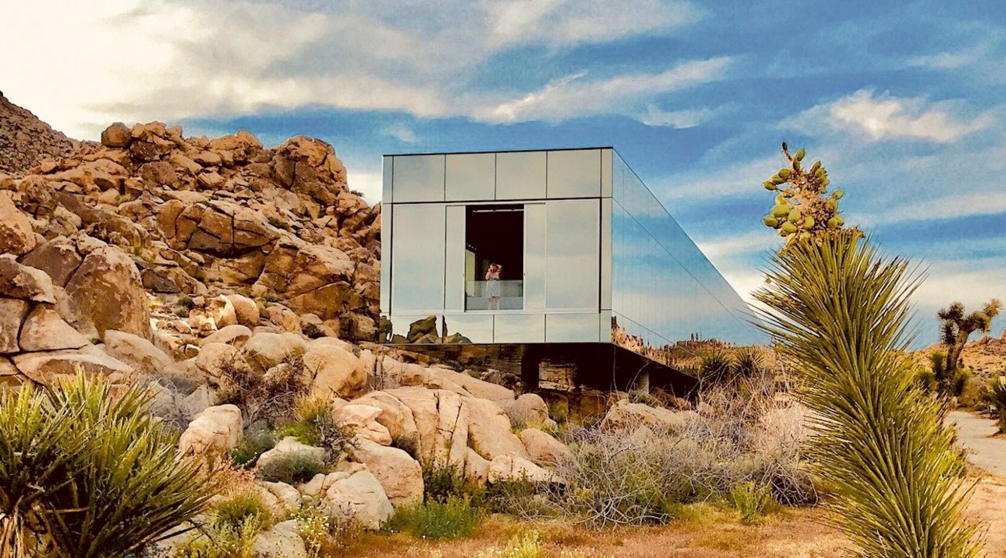 A mirrored desert home set against a backdrop of the desert.