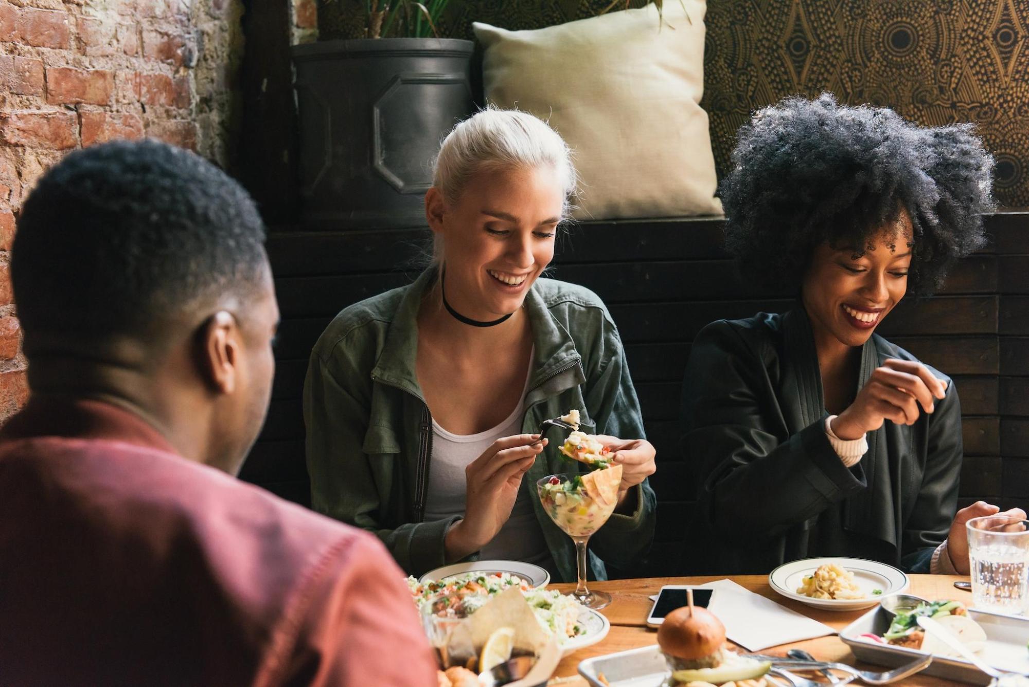 Three friends enjoying a delicious meal together 