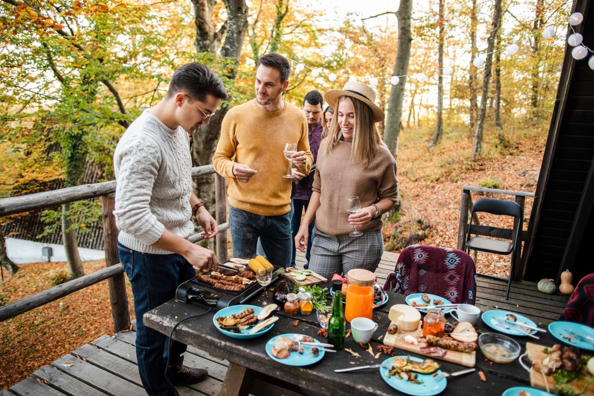A group of friends share food outdoors for a Friendsgiving