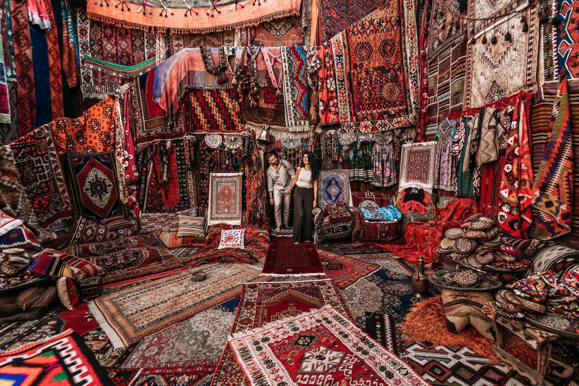 A man and woman explore a rug shop in Istanbul