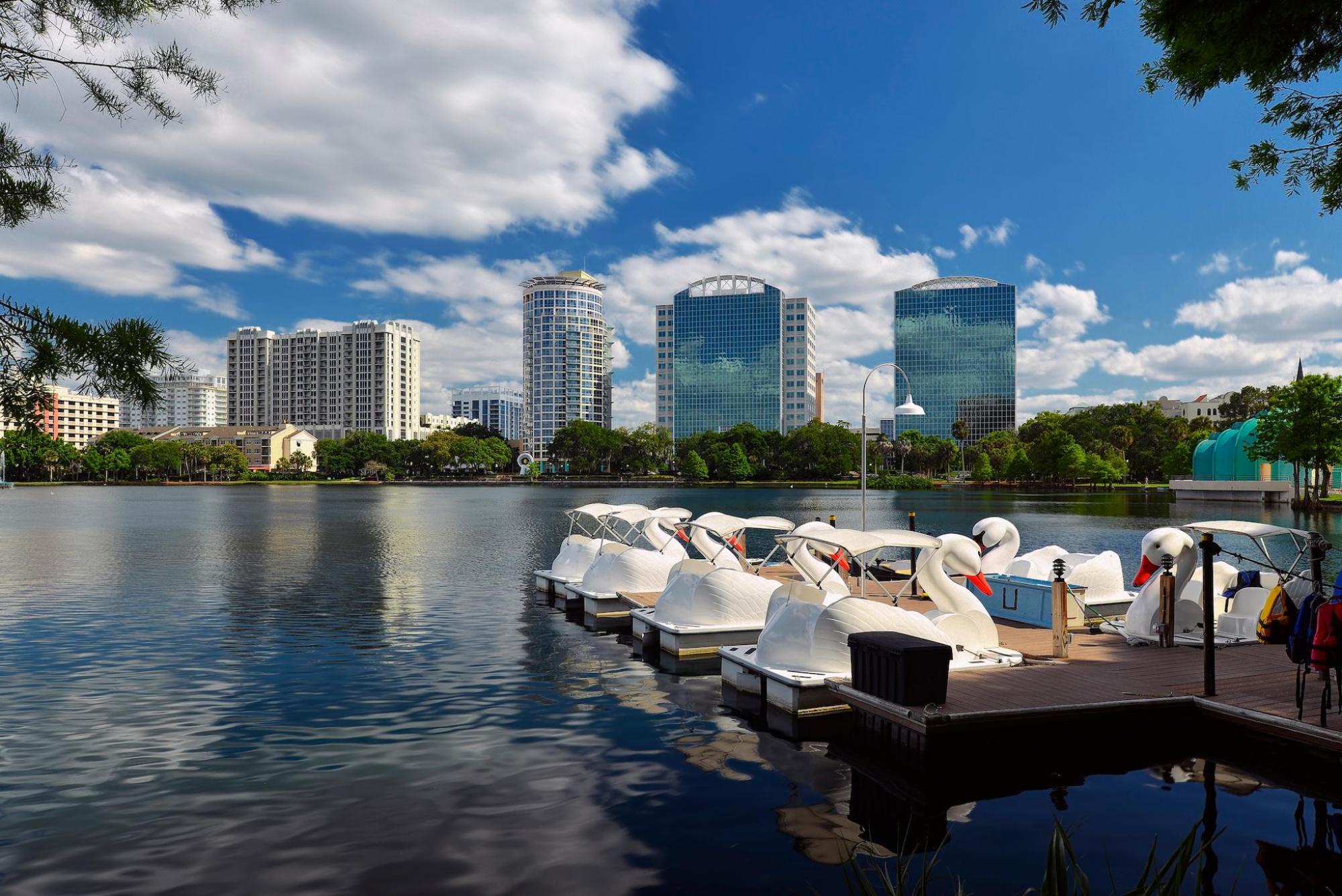 Swan paddle boats on Lake Eola, surrounded by lush greenery