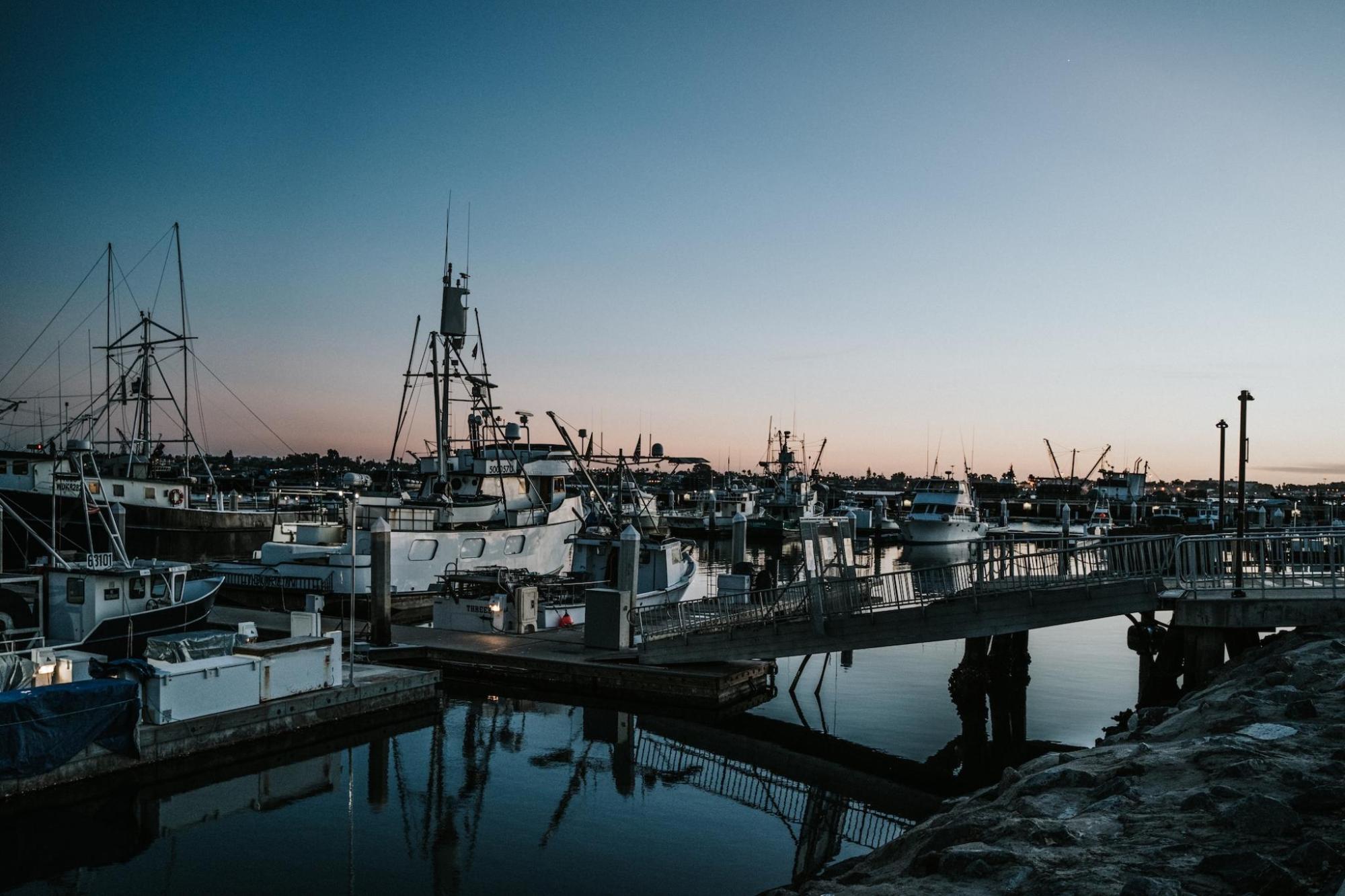 Boats docked at sunset in San Diego reflect on the water