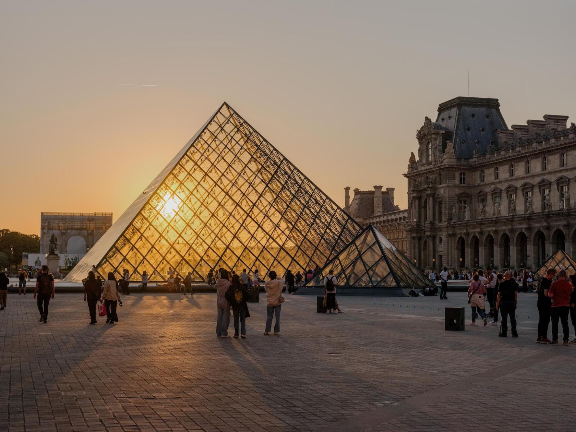 The Louvre Museum illuminated by a warm sunset