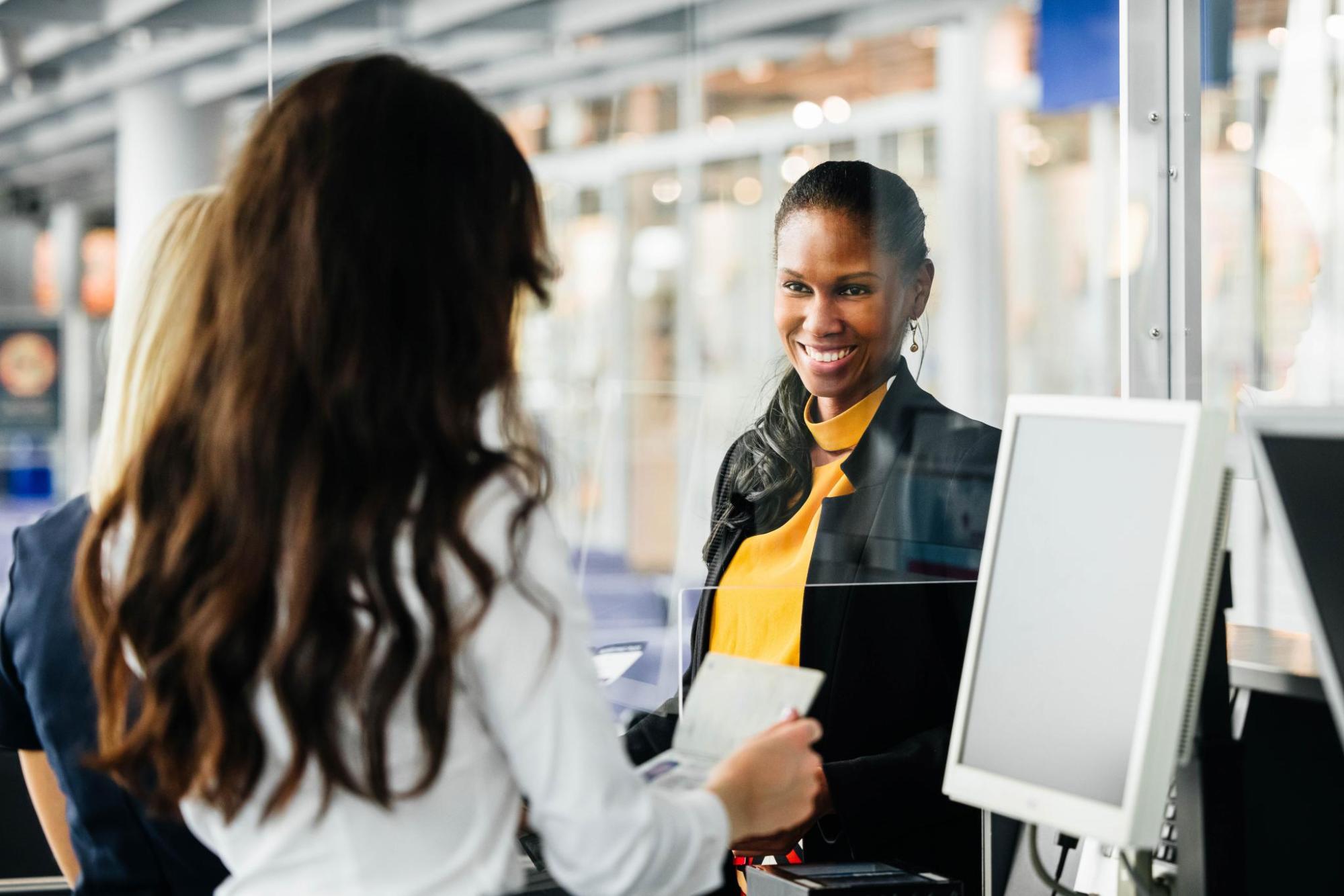 Staff member assisting a traveller at an airport check-in desk