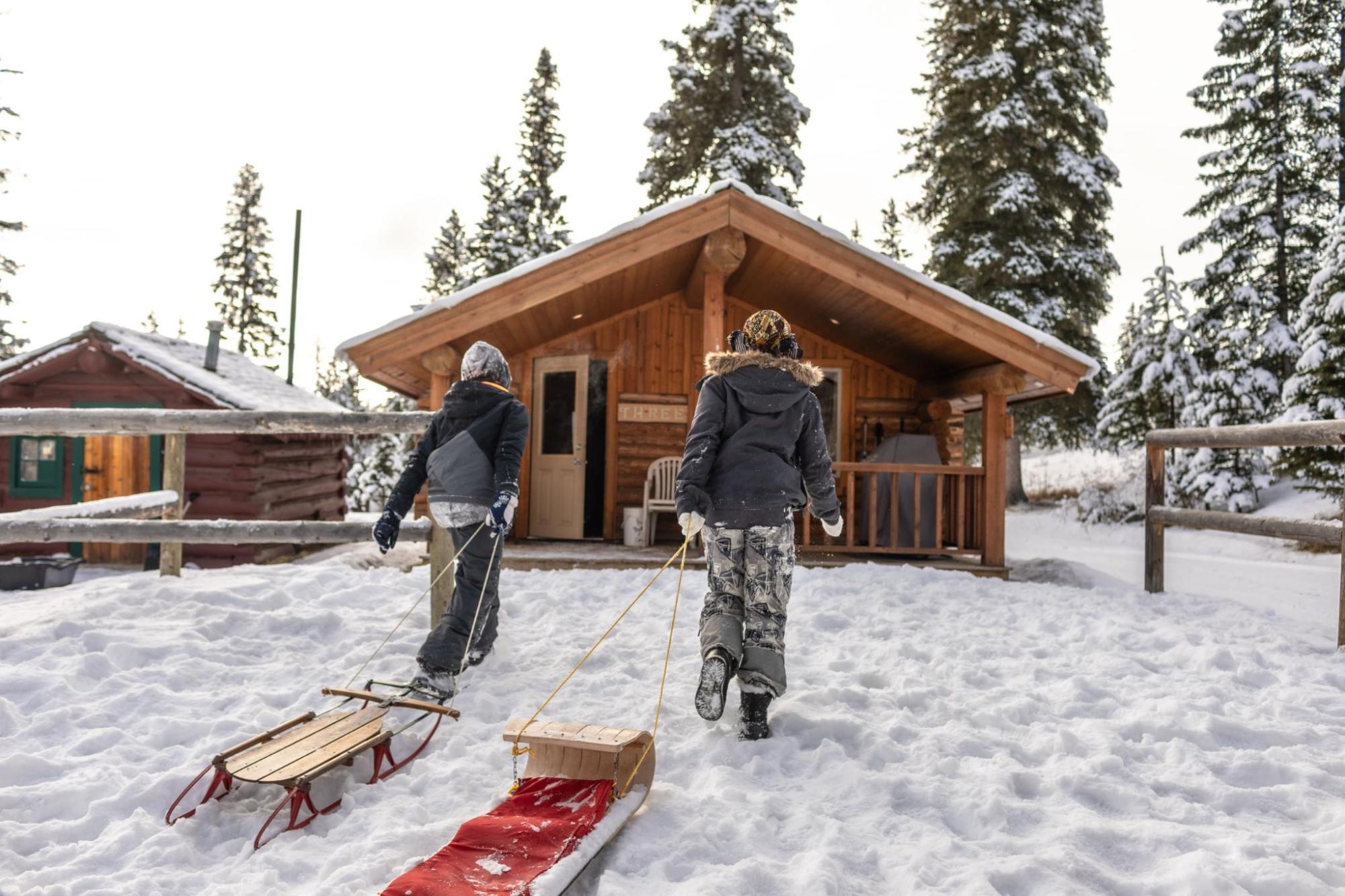 Two people walking through the snow to a holiday home
