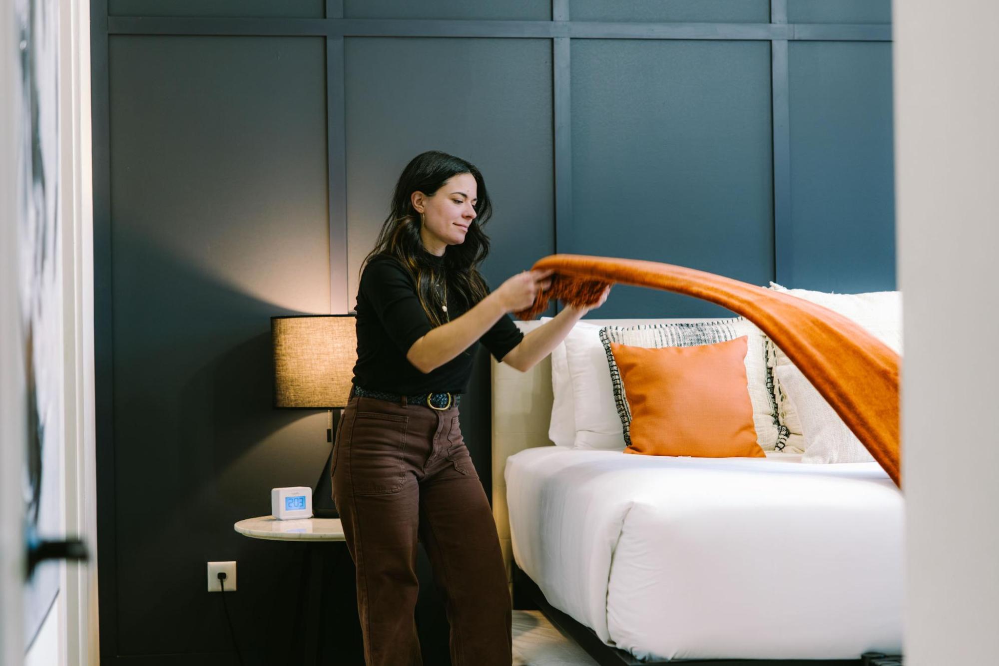 A turndown service attendant making the bed in a hotel