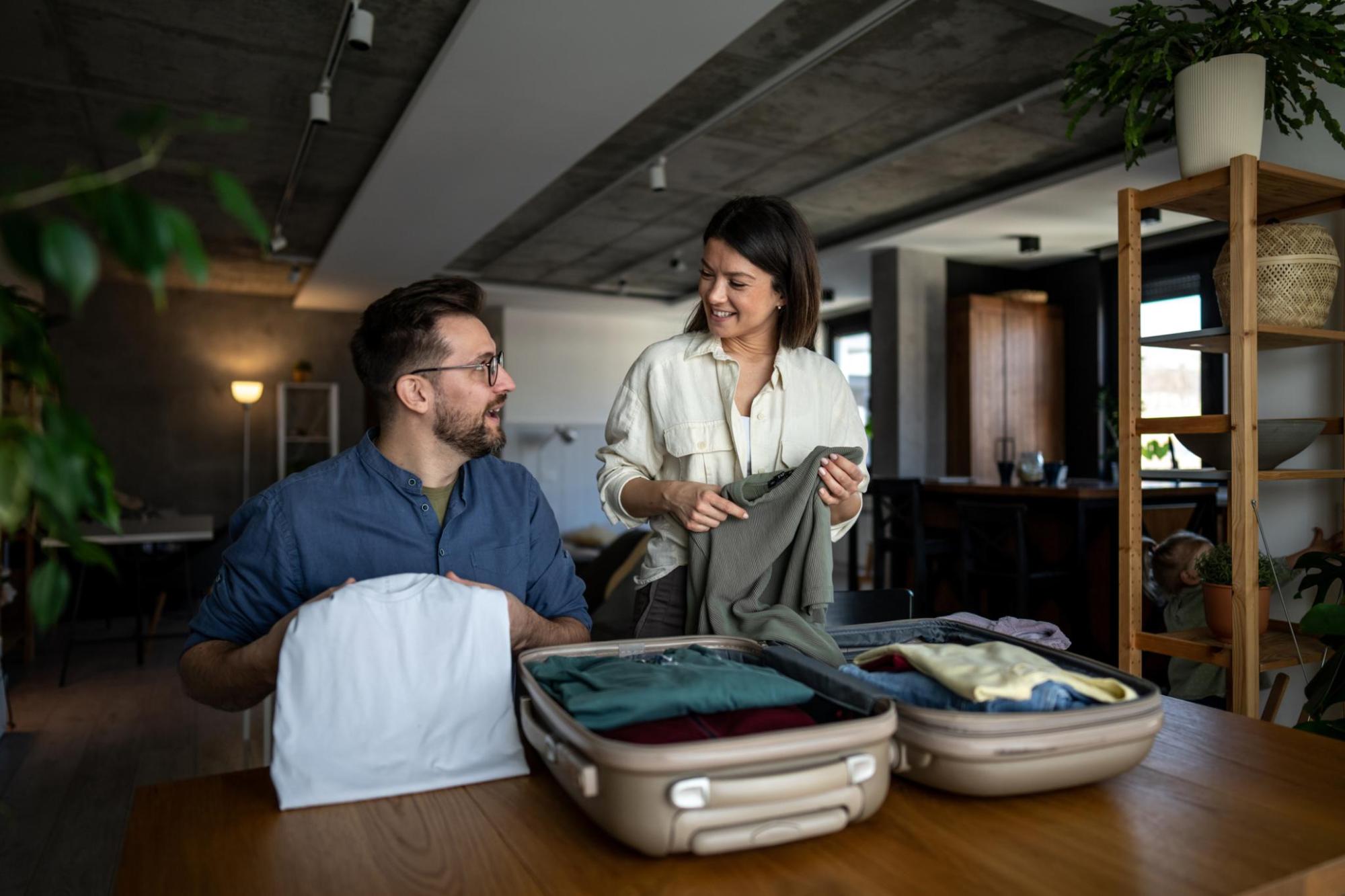 Man and woman packing a suitcase ahead of travelling.