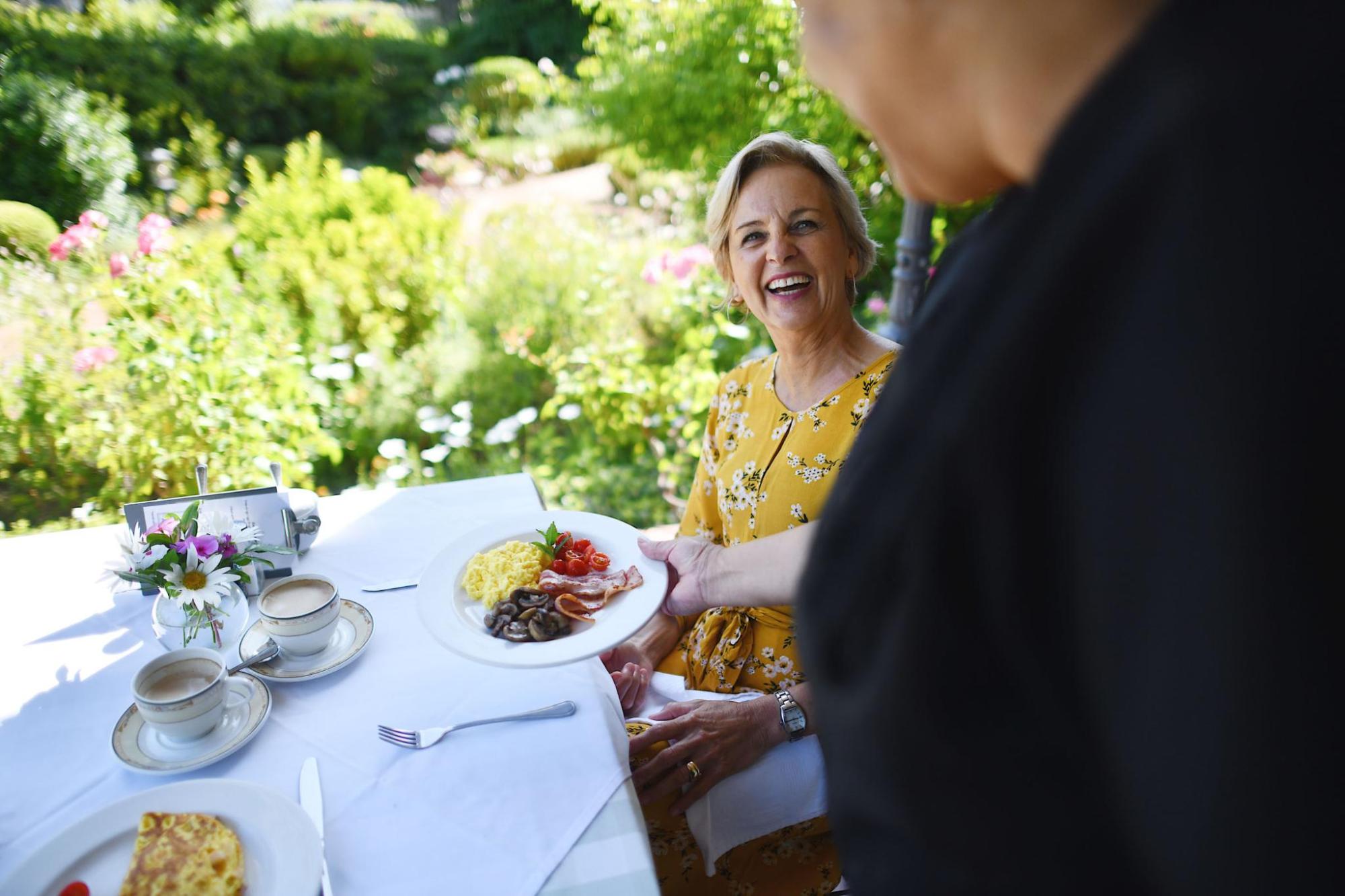 Guest served breakfast outdoors at a guest house