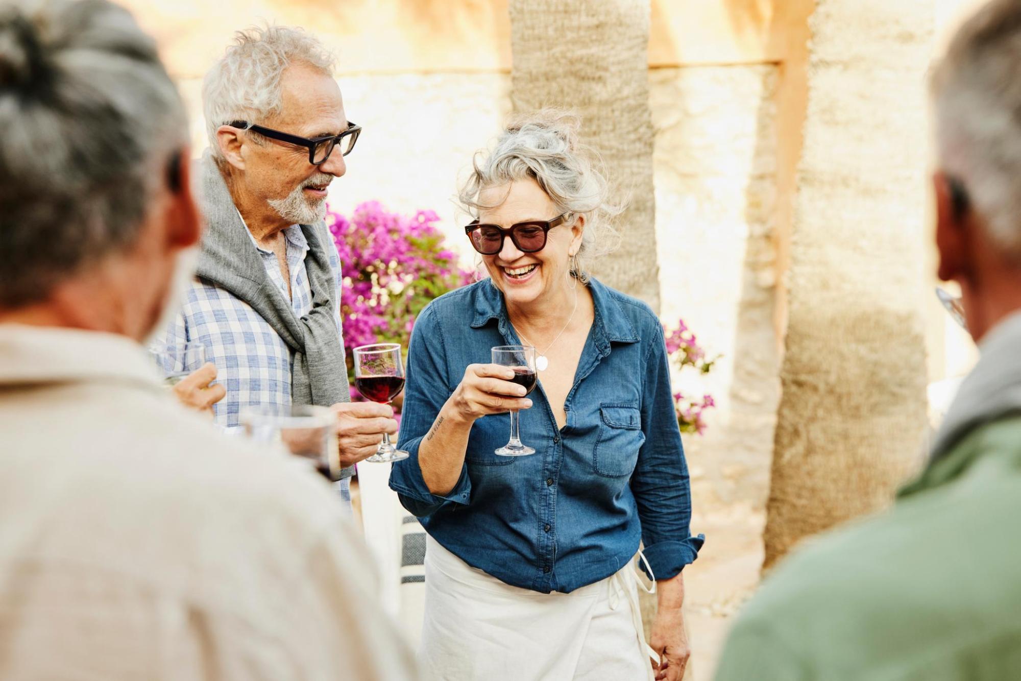 Senior couple enjoying drinks together, smiling and relaxed.