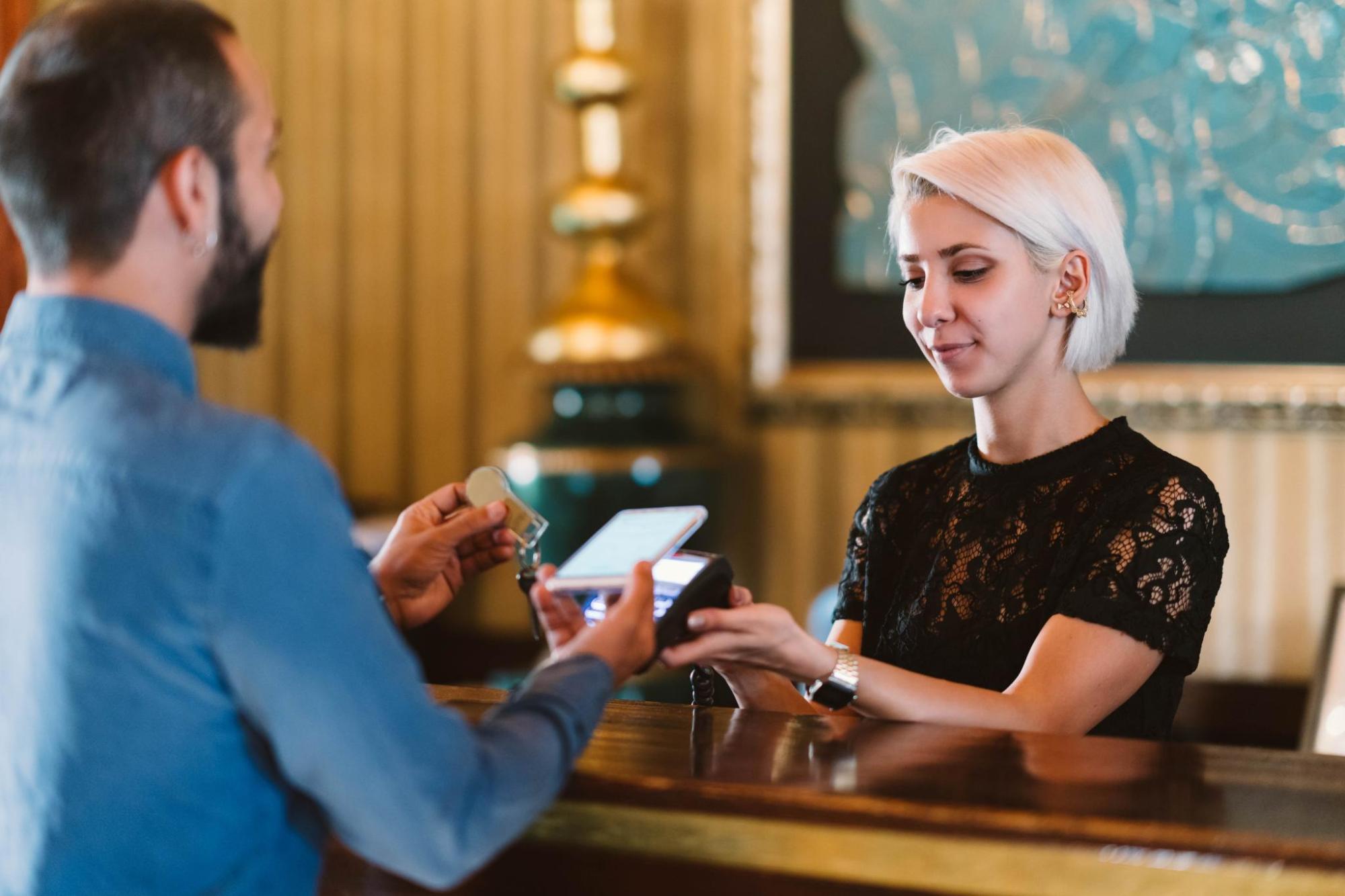 A man checking in at a hotel desk.