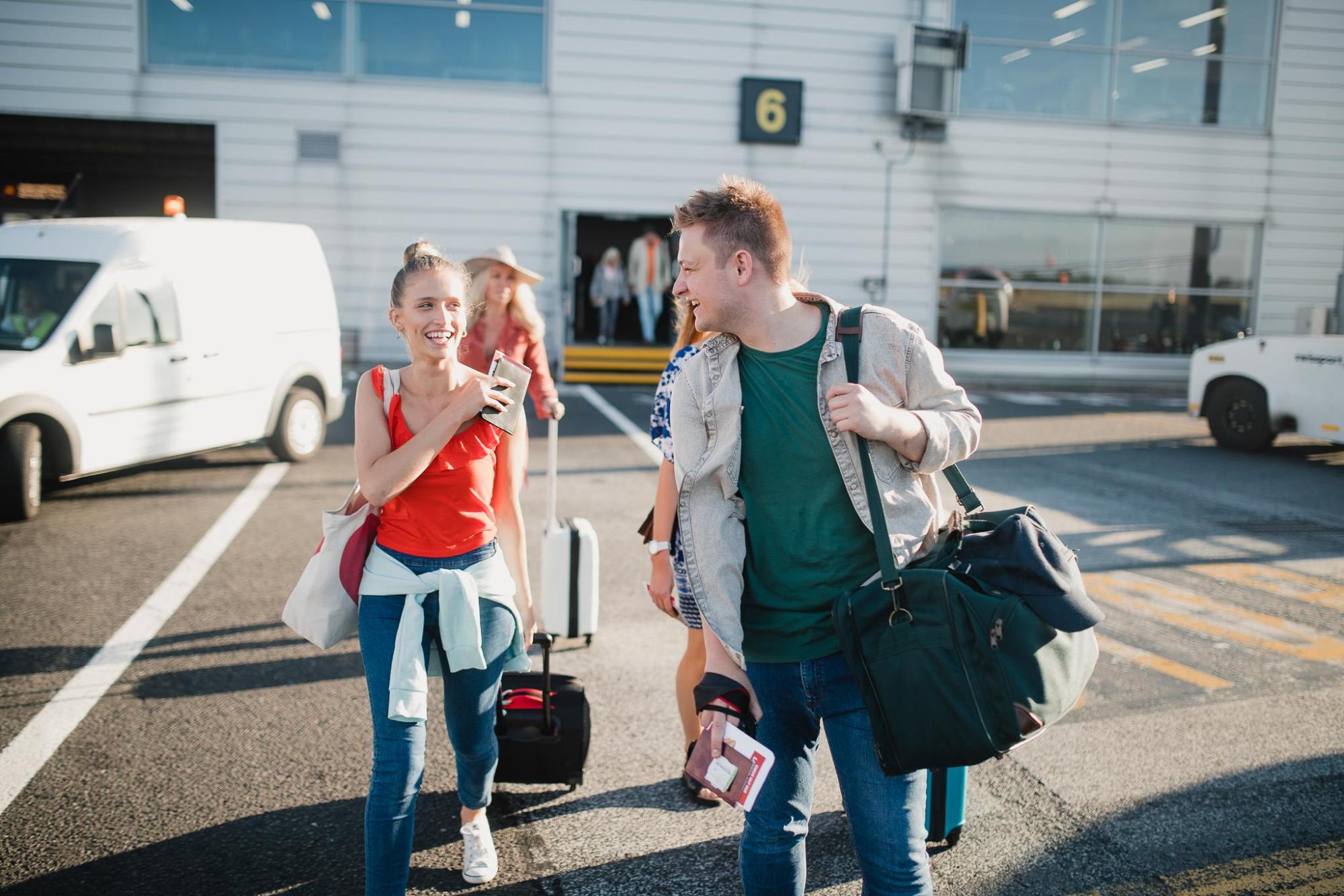 Young travellers with luggage navigating an airport terminal