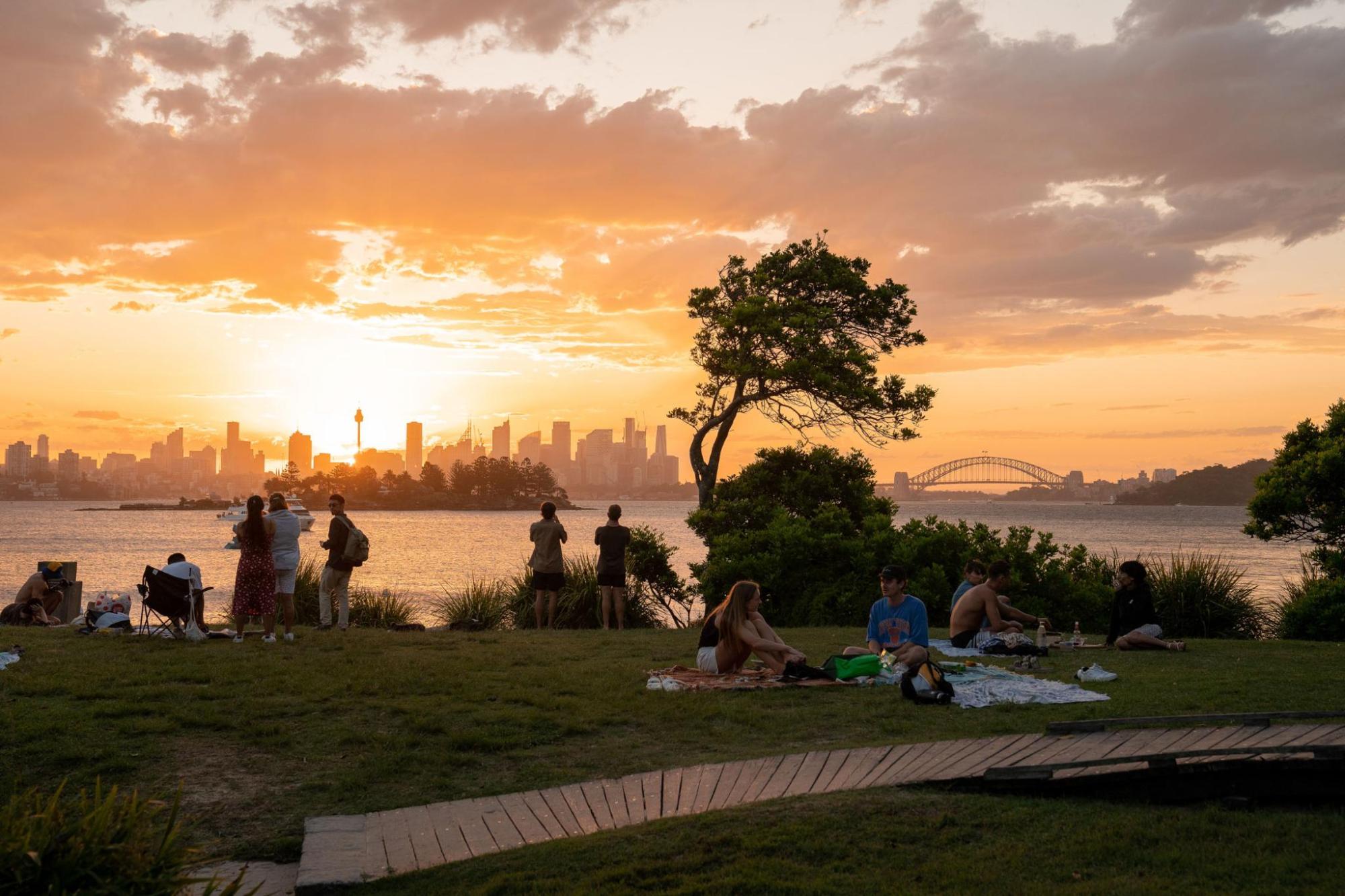 Sydney skyline at sunset with people in park