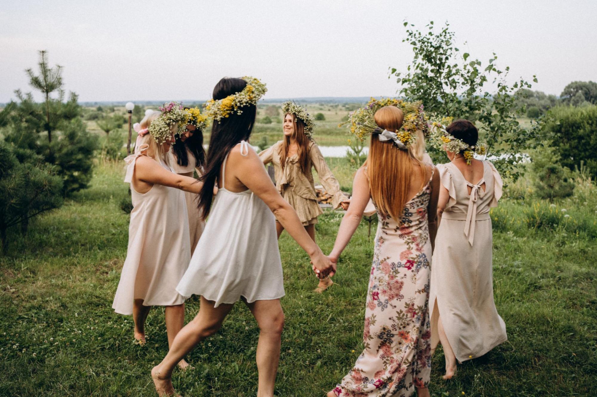 People dressed holding hands and dancing for summer solstice
