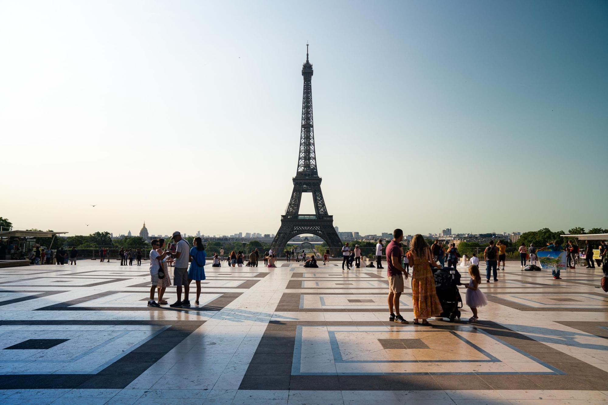 A view of the Eiffel Tower against a clear sky.