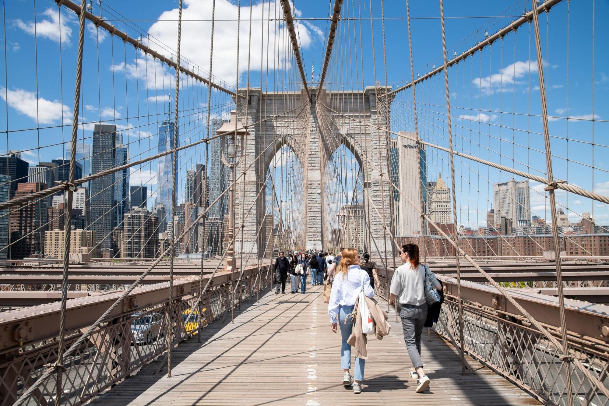 People walking across the Brooklyn Bridge.