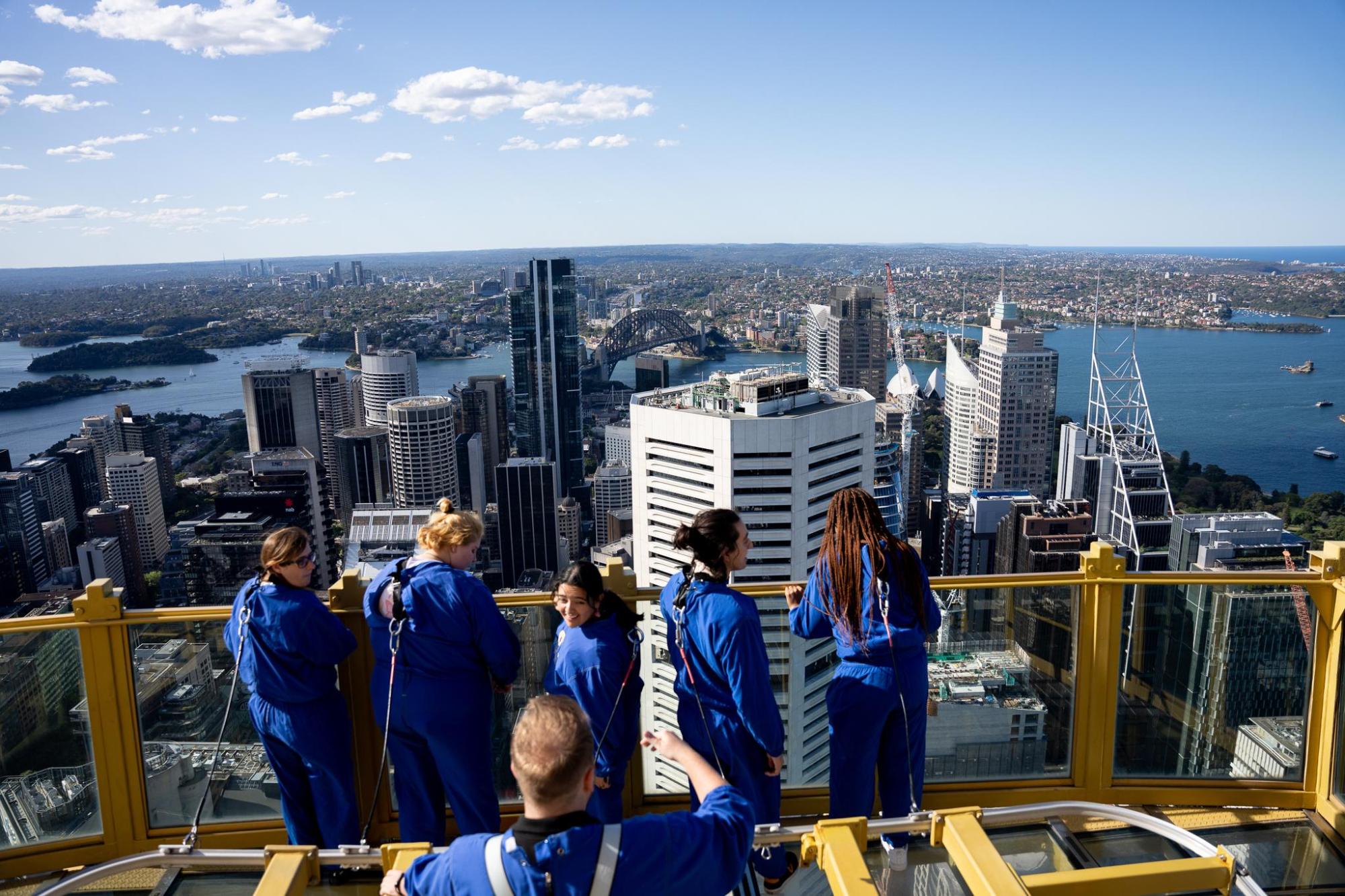 Visitors overlook Sydney Harbour from rooftop viewpoint
