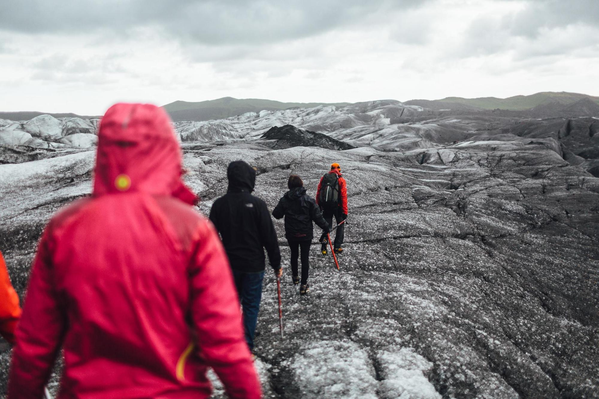 A family hikes a glacier in Iceland on an icy terrain