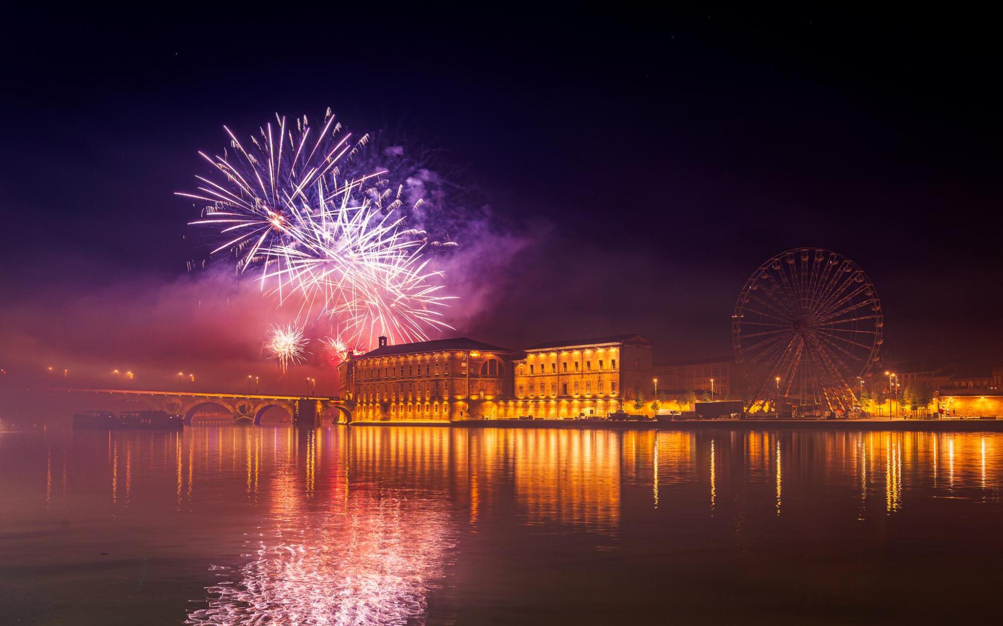 Fireworks above illuminated waterfront buildings