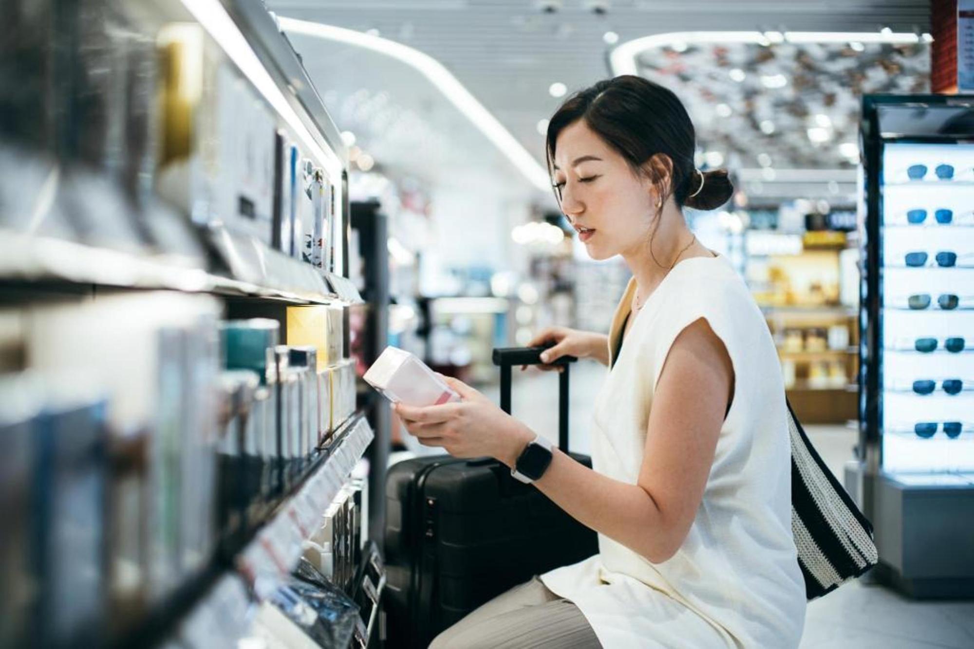 A woman looking at an item while shopping at duty-free