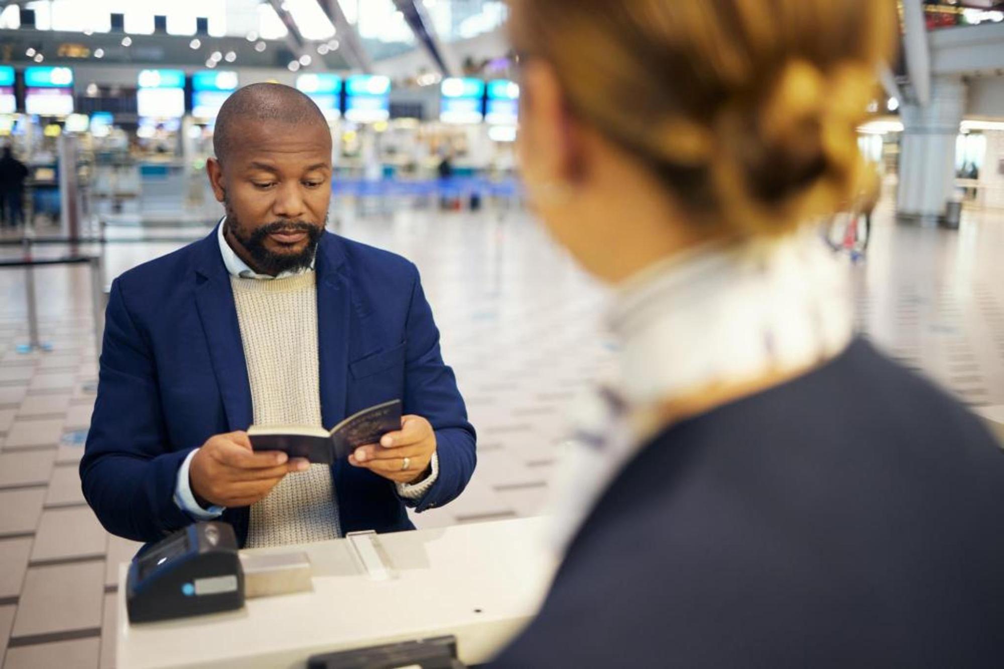 A man holding his passport before checking in to his flight