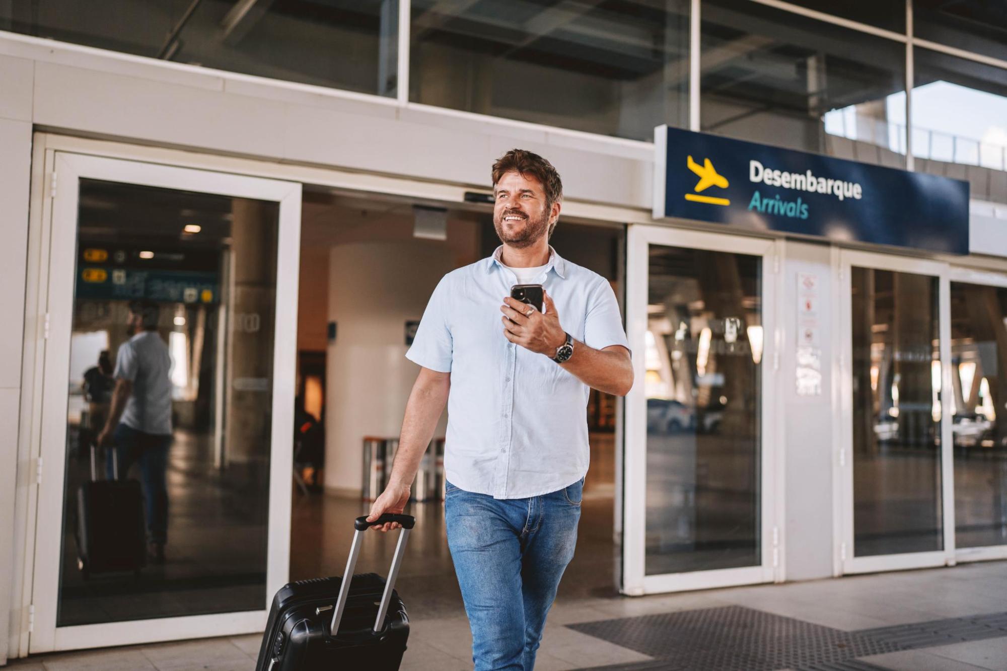 A man carrying a suitcase while exiting the airport