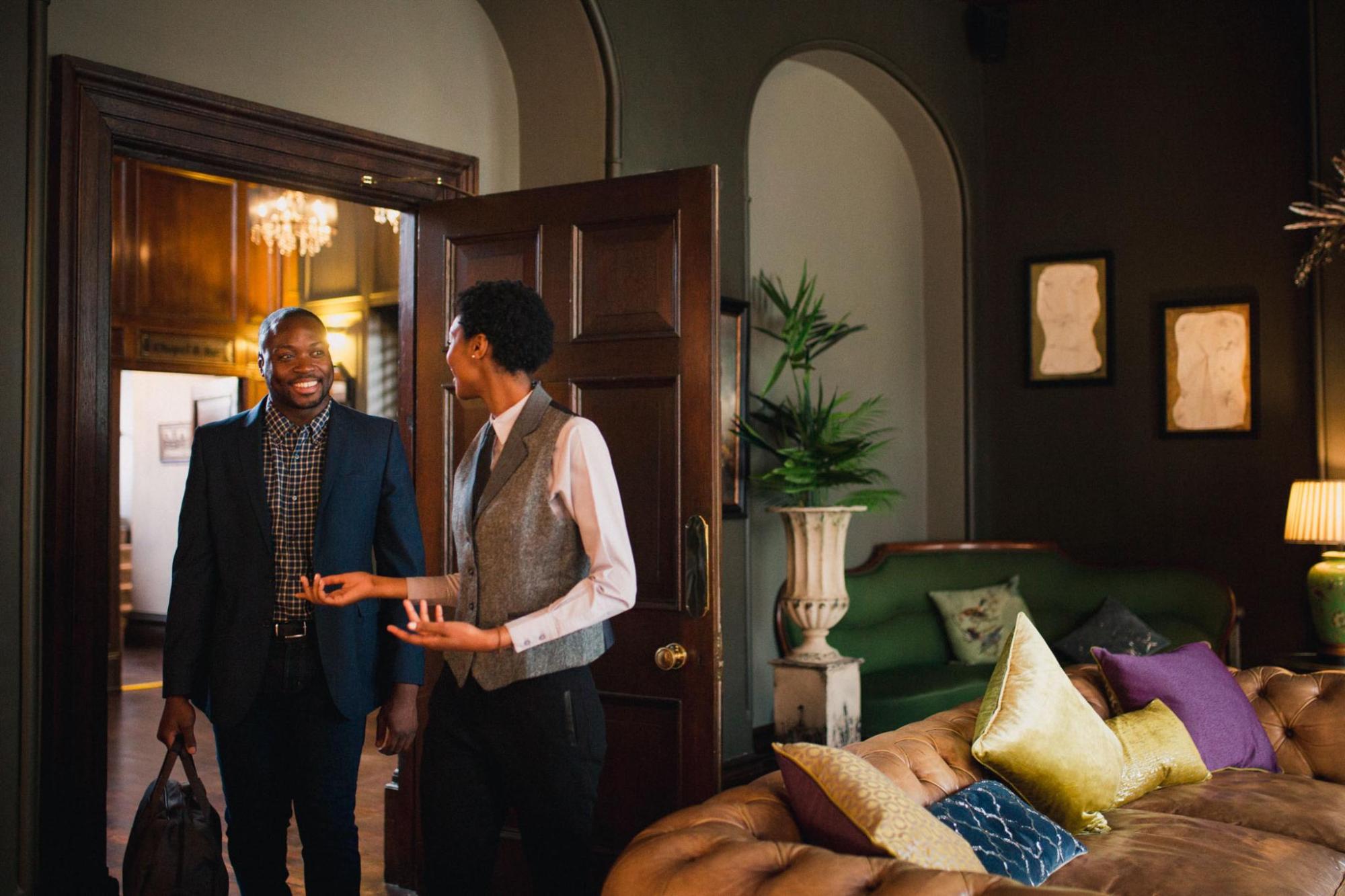 A hotel concierge showing a guest his hotel room