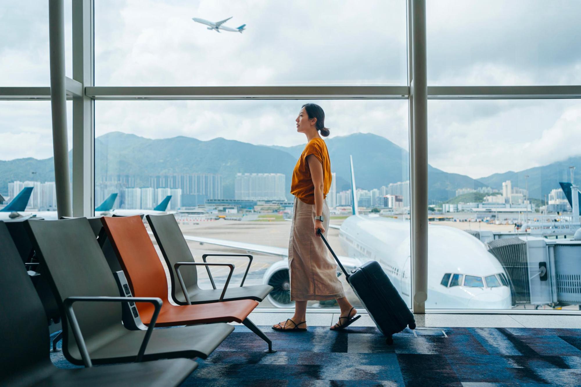 空港内を歩く荷物を持った女性