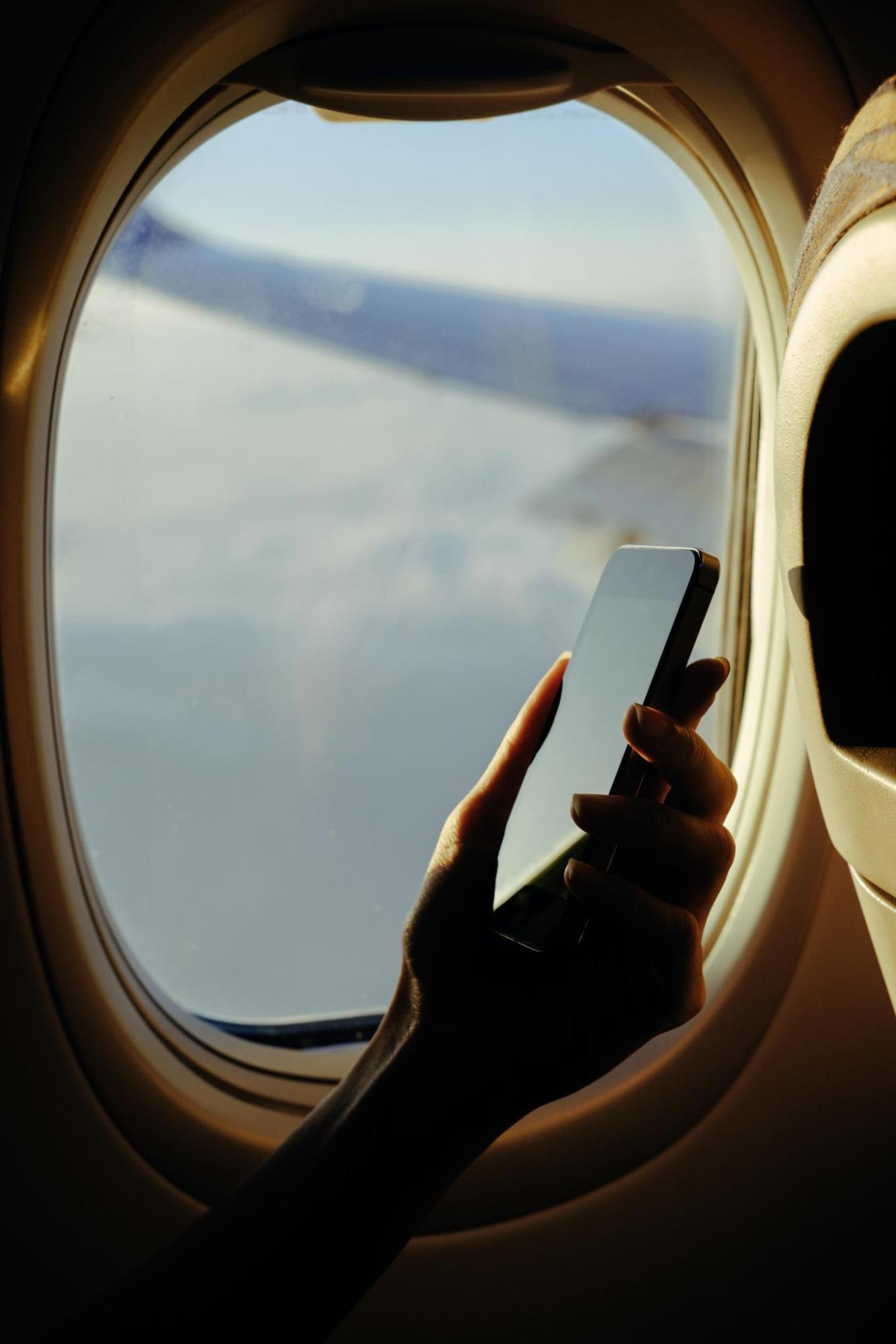 Smartphone by an airplane window during a flight