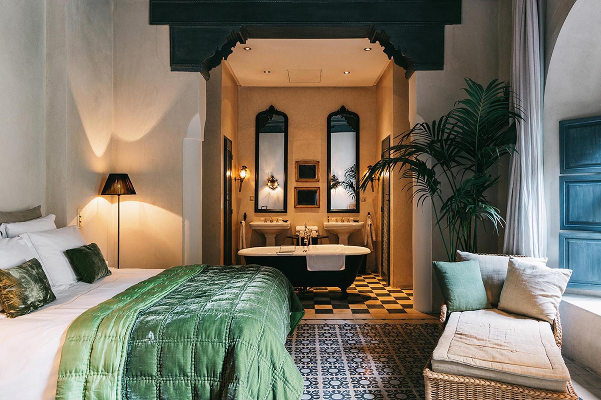 A bedroom featuring a green bed and an adjoining bathroom
