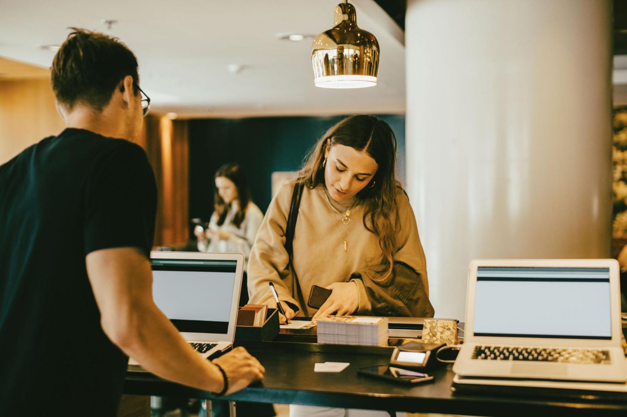 Woman arriving at a hotel reception desk