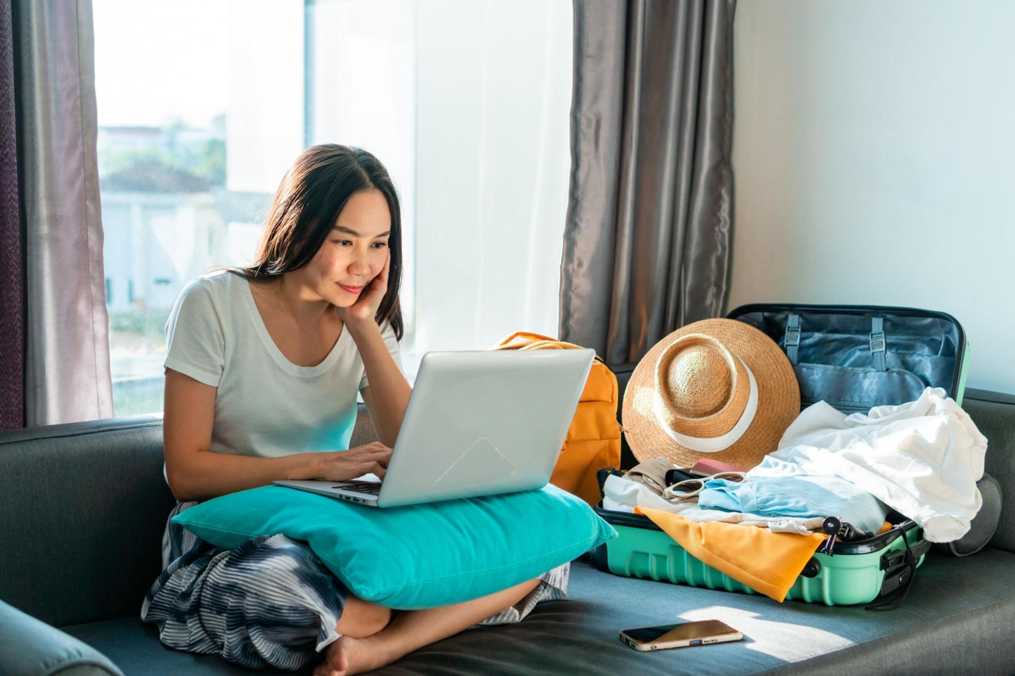 A woman sitting on a sofa looking at her laptop