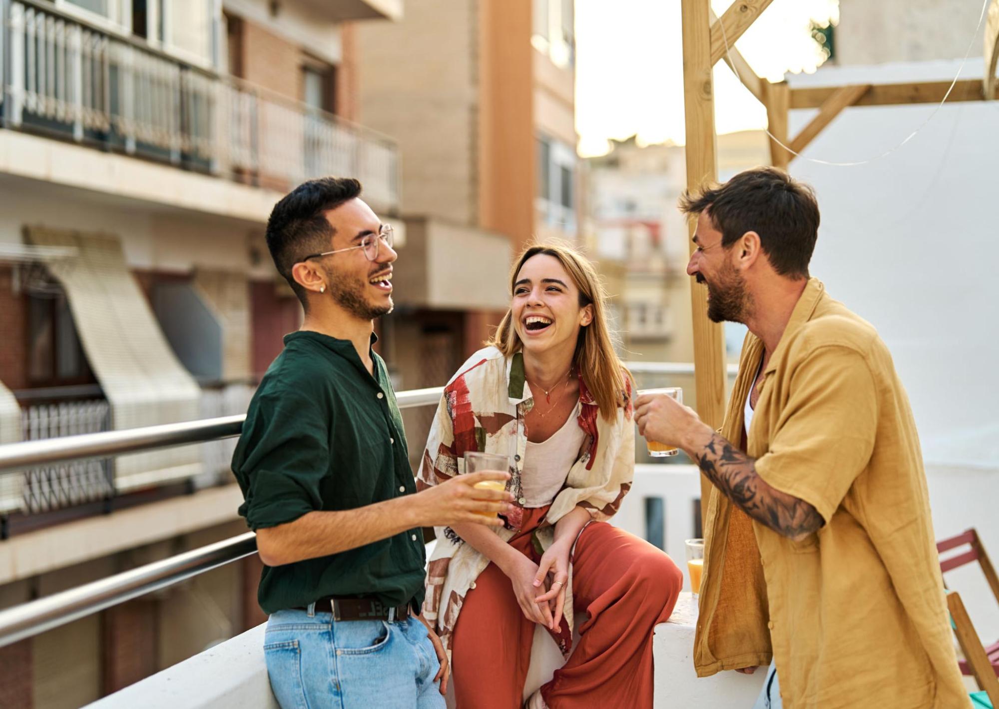 Three friends laughing together outside, enjoying their day.
