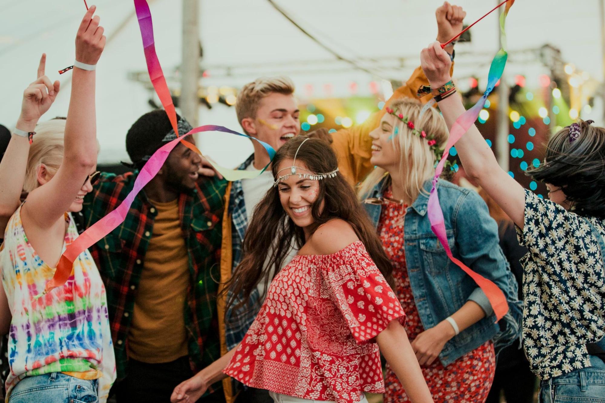 People dancing together at an outdoor music festival.