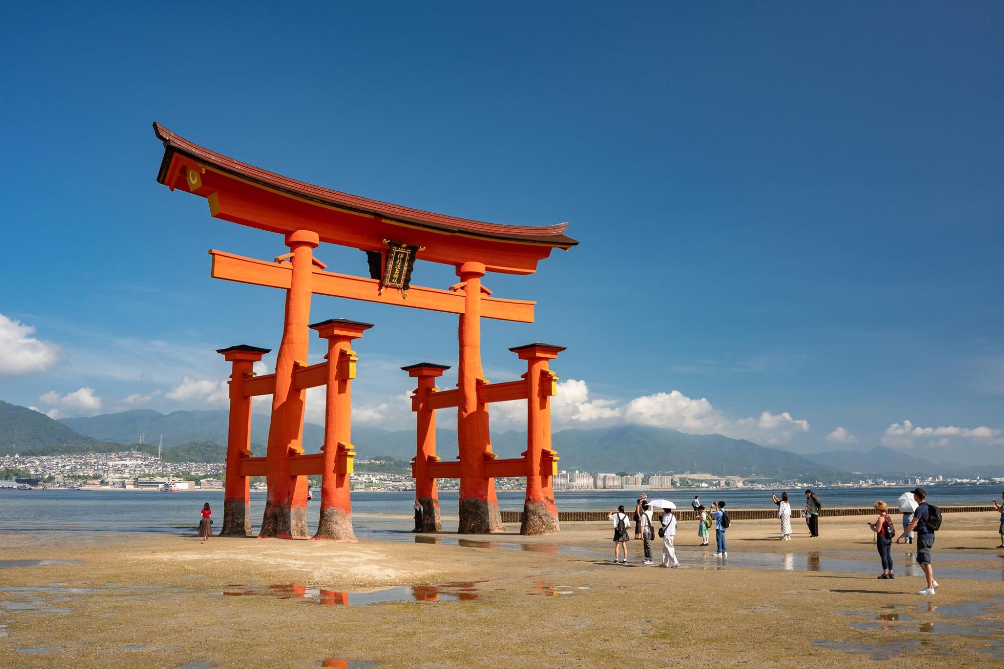 Visitors exploring Miyajima's waterfront torii gate