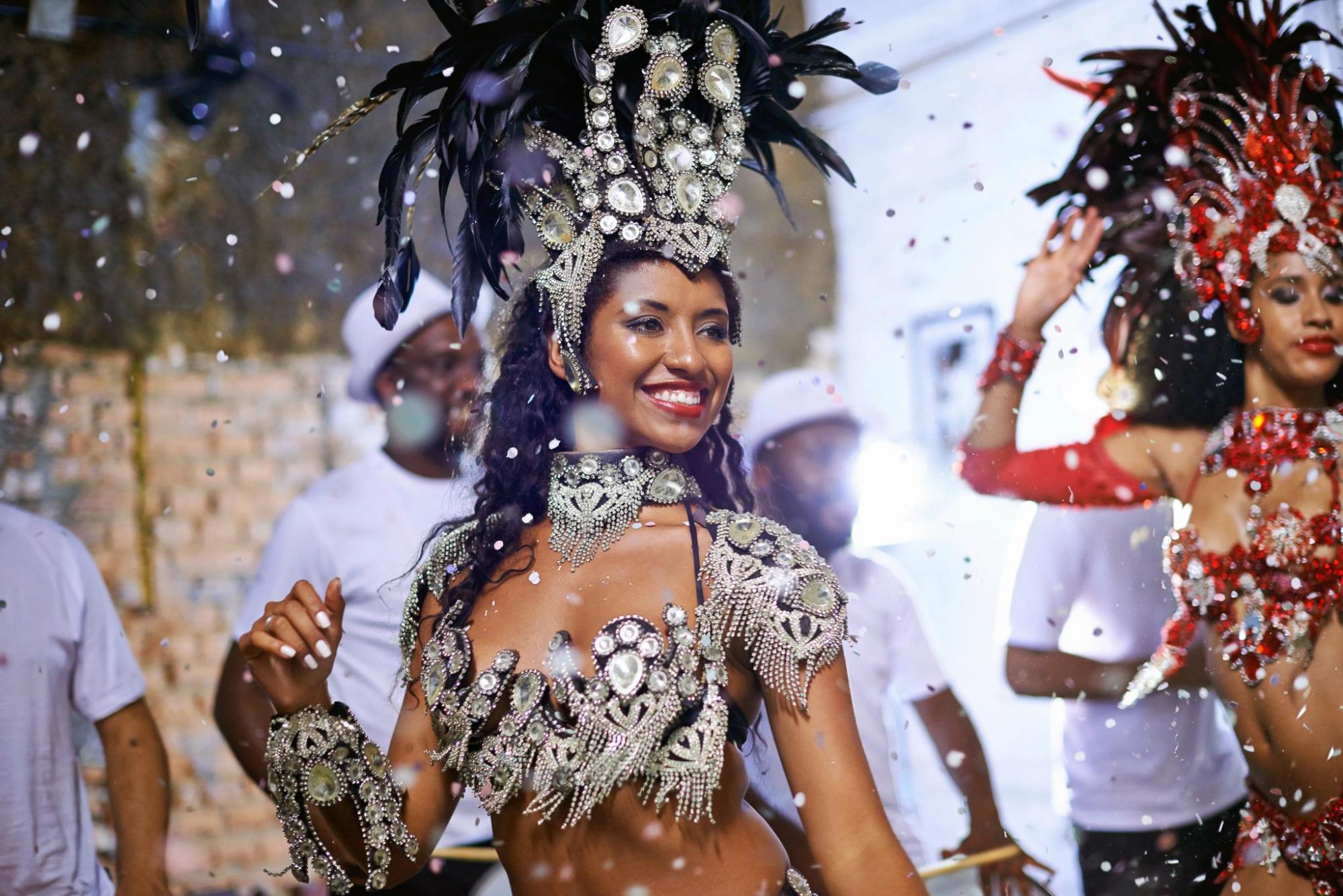 Performer in an ornate carnival costume with a feathered headdress.