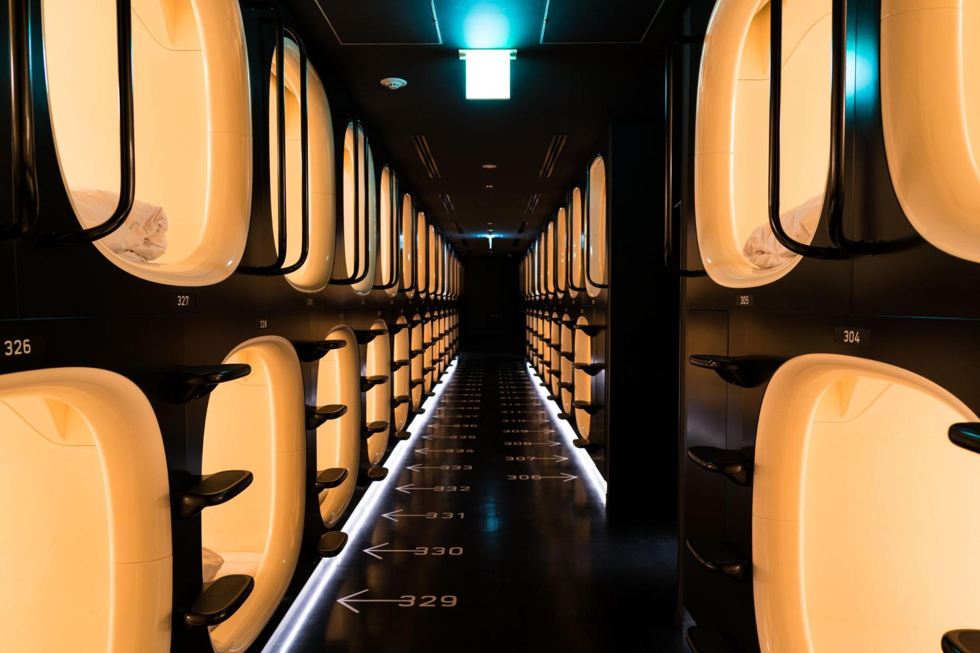 A corridor filled with capsule beds aligned along the walls