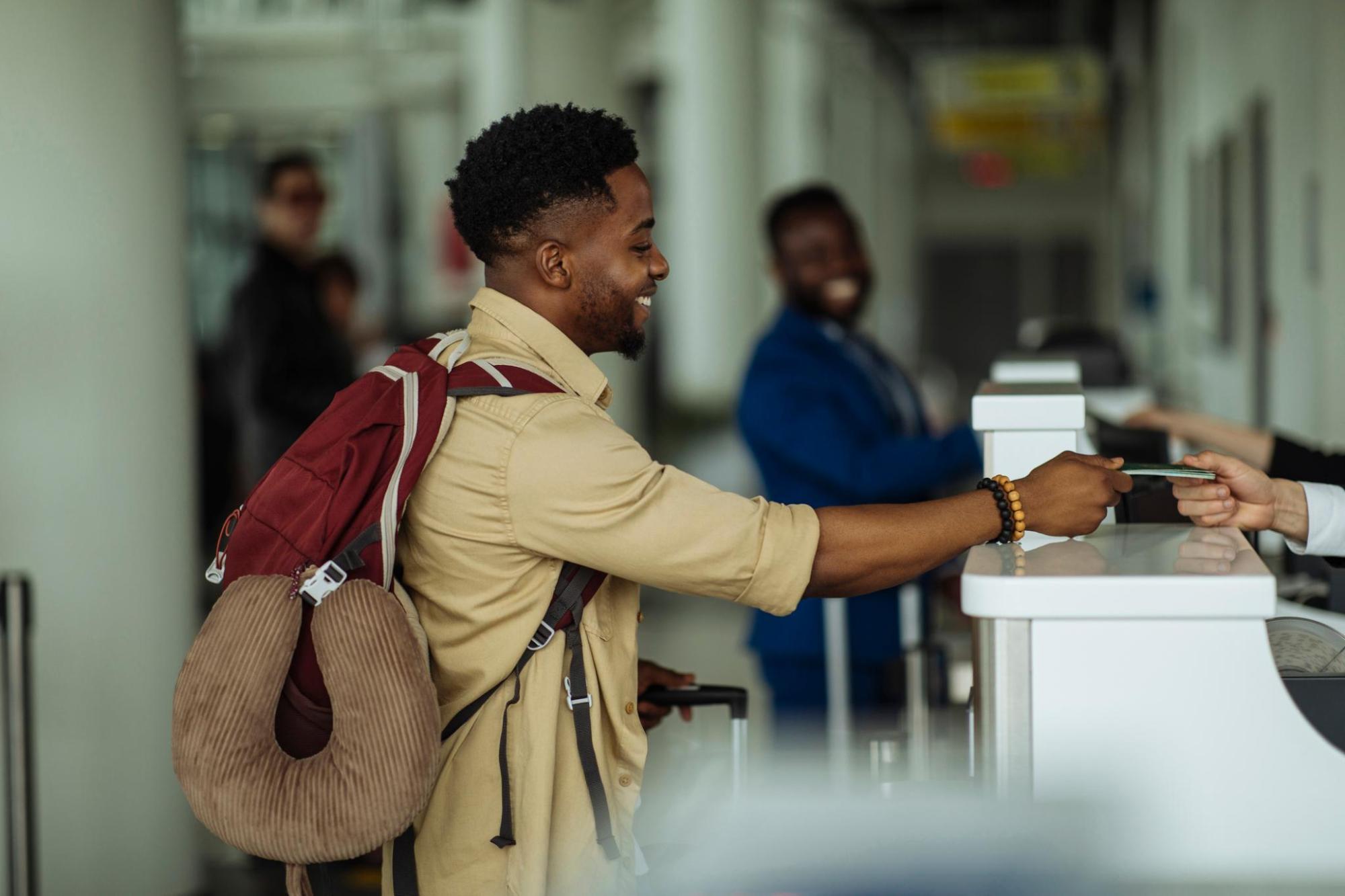 Traveller with a backpack handing over a card at a hotel reception desk