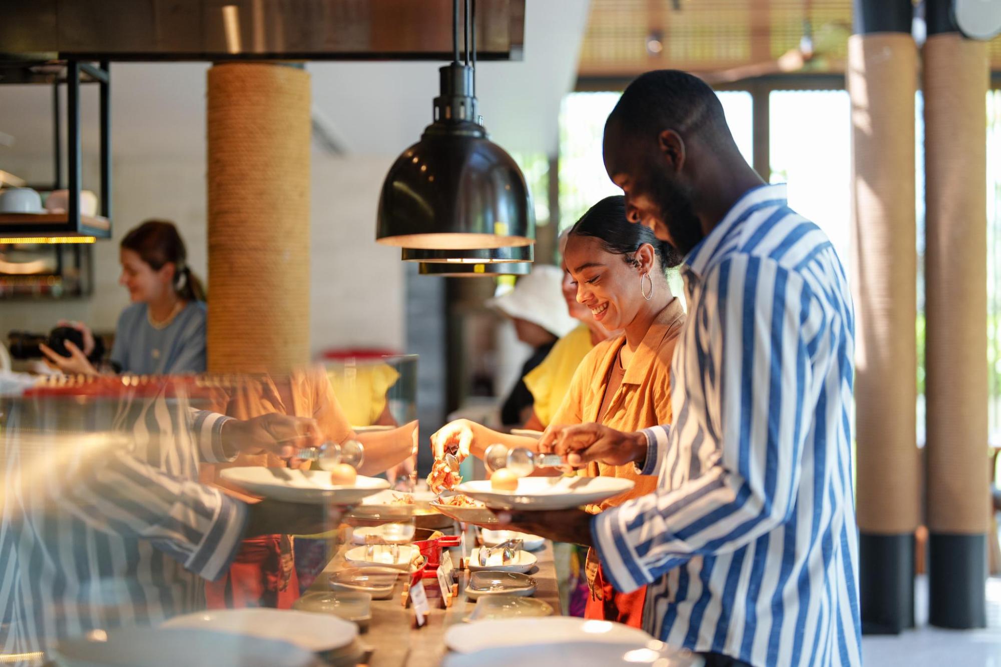 Guests choosing food from a buffet and serving themselves